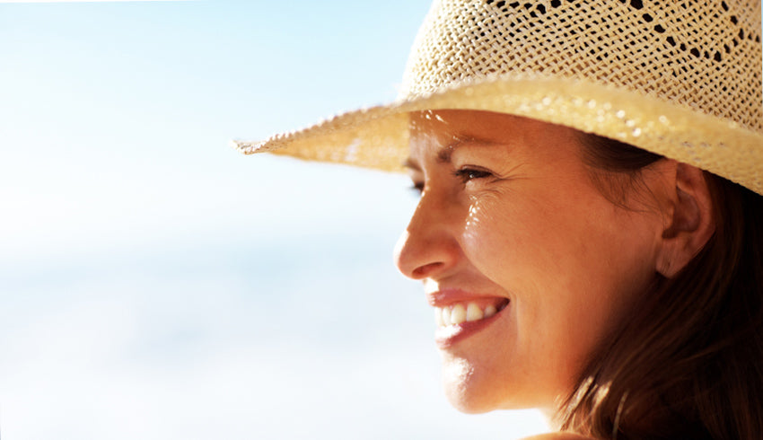 Lady wearing hat and heliocare for sun protection, protecting from photoaging and hyperpigmentation with Heliocare NZ and Fernblock